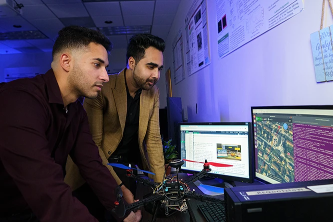 Jean Tonday Rodriguez and Mohammad Kumail Kazmi in the The Analytics for Cyber Defense lab.