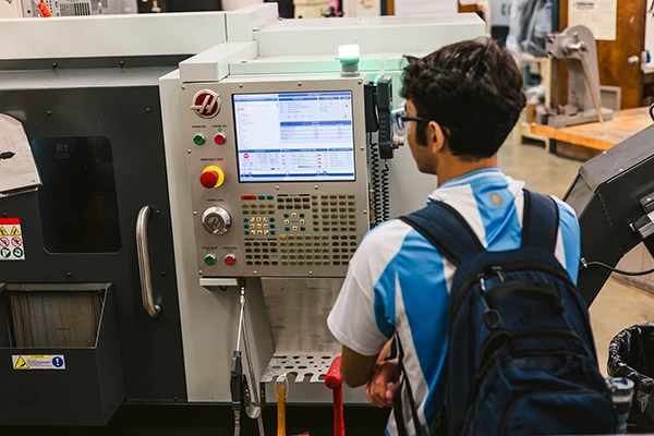 FIU student looking at screen on mechanical device